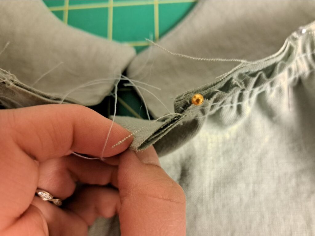 hand holding back skirt pinned onto bodice, showing how placket extends past bodice